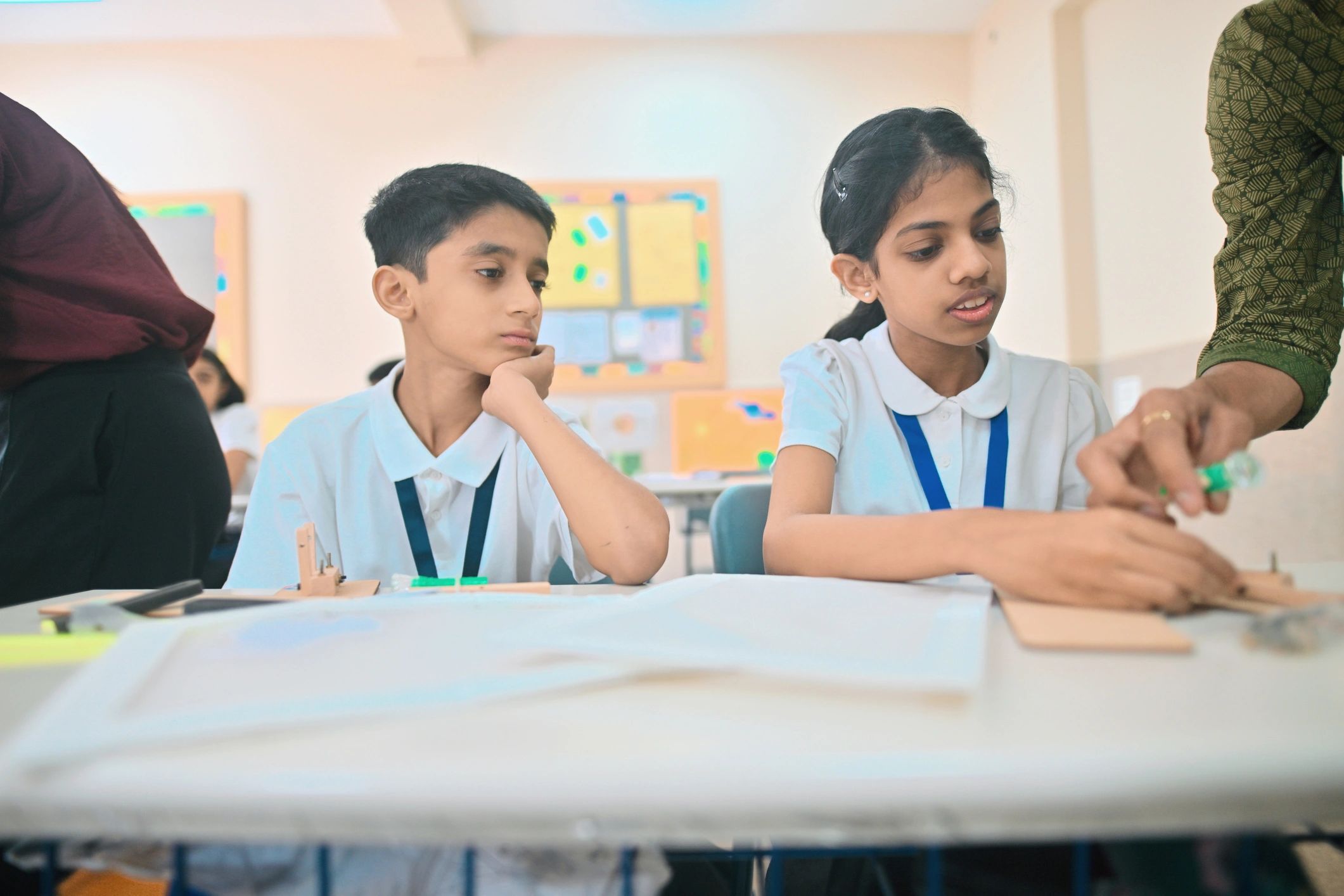 Teacher helping students with a hands-on classroom project